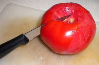 Cored whole tomato ready to halve