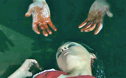 Tracy on ground and bloody hands over her